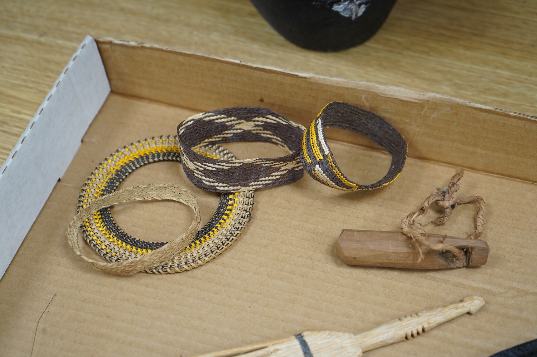 A collection of tribal carvings, straw bags, an abacus- 29cm wide and boomerang
